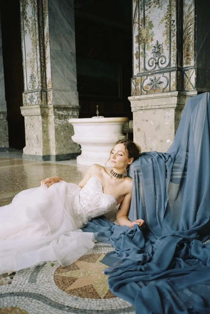 Bride reclining in a palazzo with blue drapery
