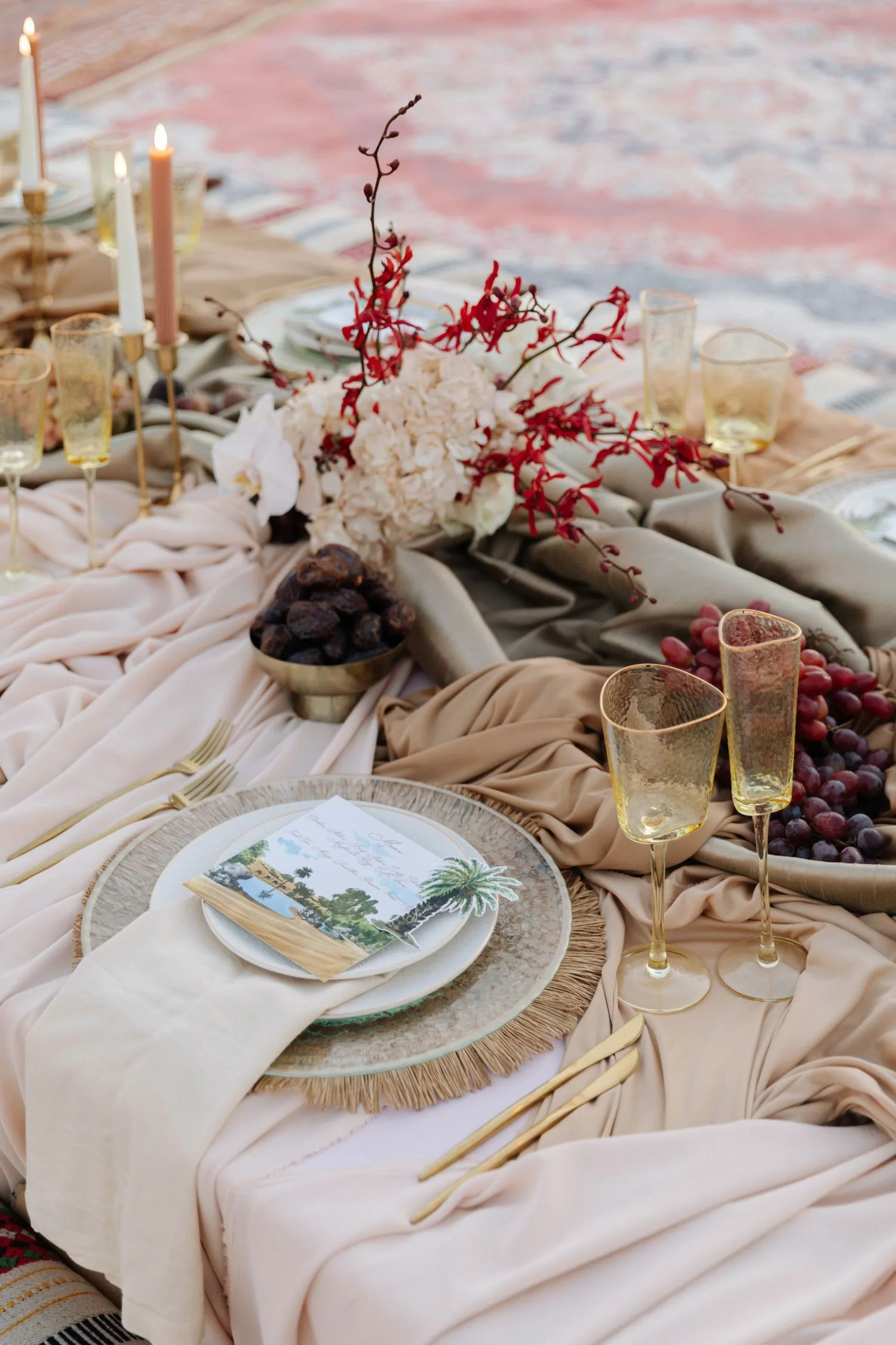 Elegant desert wedding table setting with decorative plates and red floral accents at Al Maha Resort Dubai