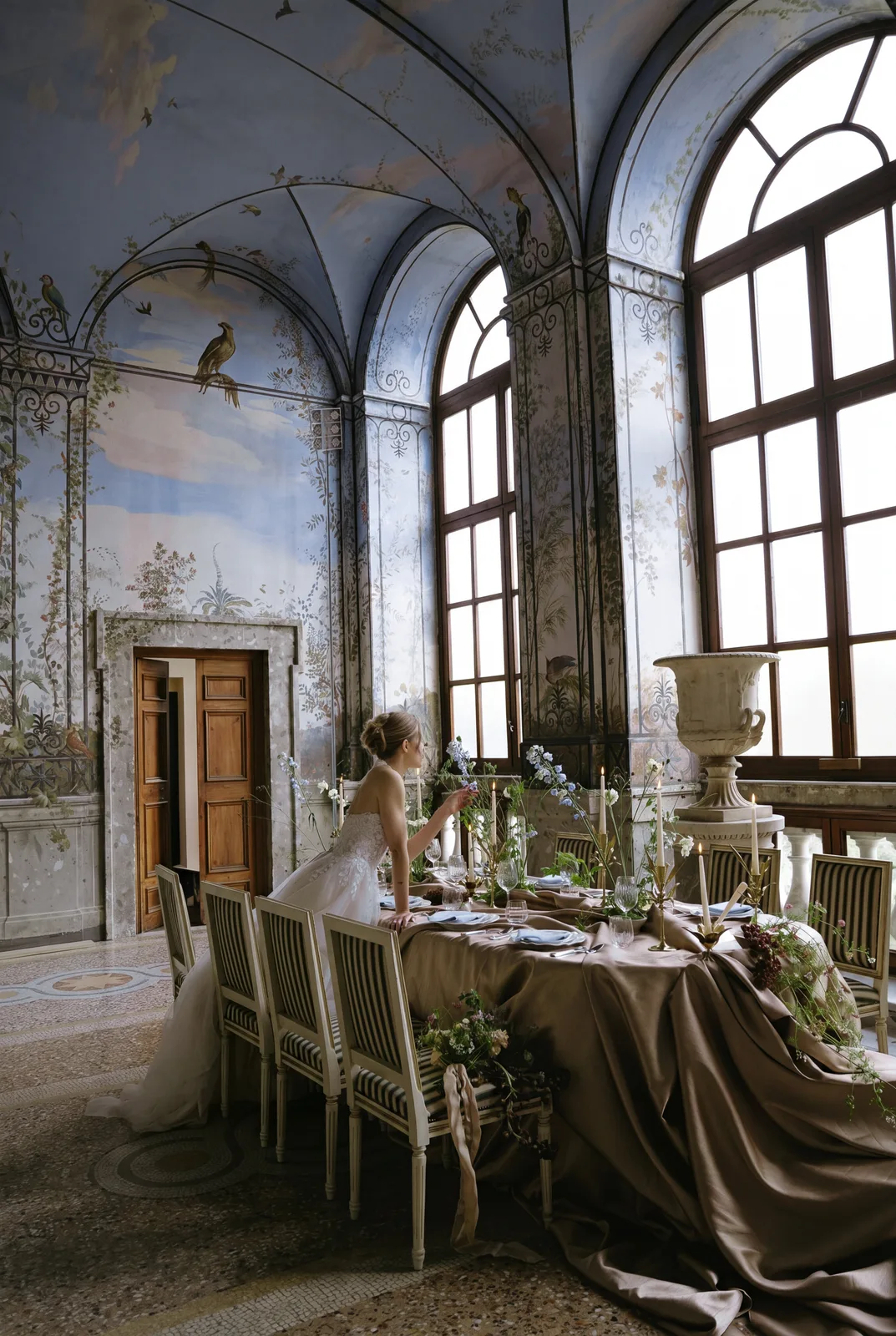 Bride seated at a table draped in bronze silk inside the frescoed Salone d'Estate of Palazzo Chigi in Ariccia, near Rome