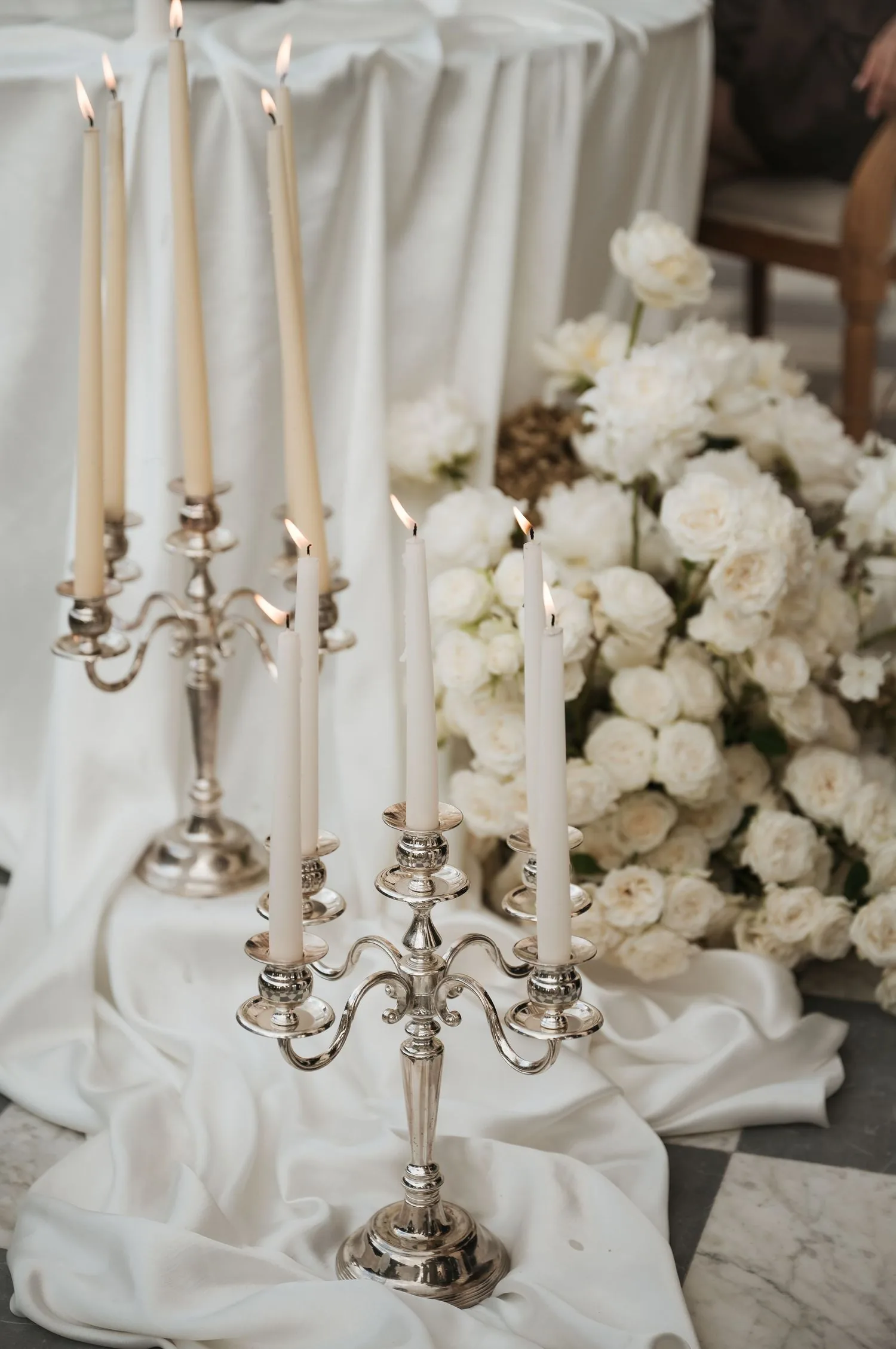 Tall silver candelabras with ivory candles and garden roses at Villa Astor reception